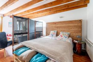 a bedroom with a bed with a wooden wall at Maison familiale sud Nantes in Bouguenais