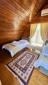 - une chambre avec 2 lits et un tapis au sol dans l'établissement Zeyve Bungalov Tatil Köyü, à Karaman