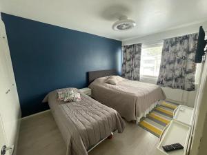 a bedroom with two beds and a blue wall at Kempele city center in Kempele