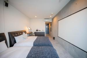 a bedroom with a large bed and a large projection screen at Minn Haneda Airport in Tokyo