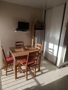 a dining room with a table and four chairs at BALARUC FAMILLE in Balaruc-les-Bains