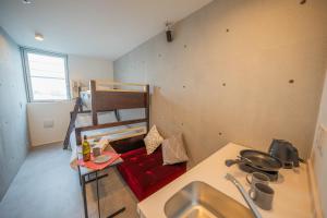 a kitchen with a sink and a red couch in a room at Minn Haneda Airport in Tokyo +3 photos