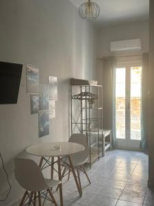 a dining room with a table and chairs and a shelf at BYZANTIUM APARTMENTS in Ermoupoli