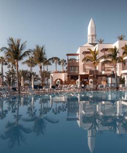 un complejo con piscina frente a un edificio en Princesa Yaiza Suite Hotel Resort, en Playa Blanca