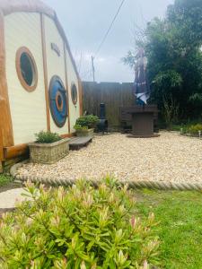 einen Garten mit einem Schuppen und einer Statue einer Frau in der Unterkunft Tyluna Cornish Cabin in Praze an Beeble