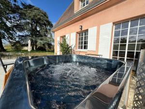 ein großer Pool mit Wasser vor einem Haus in der Unterkunft La Meslaysienne - Comfortable house, swimming pool in Meslay-le-Vidame