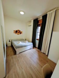 a bedroom with a bed and a wooden floor at Guest House Il Glicine Stadio - Ospedale Cesena in Cesena