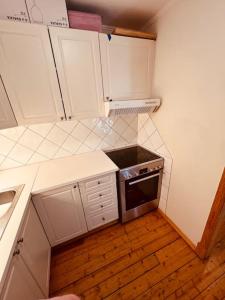 a small kitchen with white cabinets and a stove at Leilighet midt på Solsiden in Trondheim