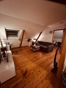 a living room with a couch and a wooden floor at Leilighet midt på Solsiden in Trondheim