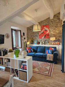 a living room with a blue couch and a stone wall at I Colori del Lago in Passignano sul Trasimeno