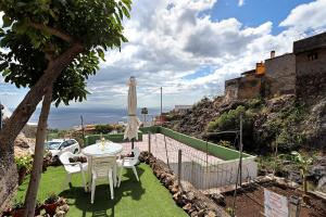 patio con tavolo, sedie e ombrellone di Villa Osli ad Araya