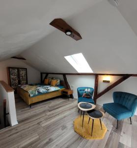 a attic bedroom with a bed and a blue chair at FeWo Todeskino ``Altstadtflair`` in Heiligenhafen in Heiligenhafen