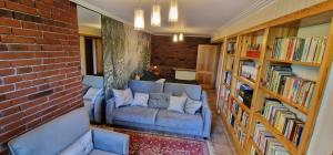 a living room with a blue couch and a brick wall at Apartament " La Dolce Vita " in Bryzgiel