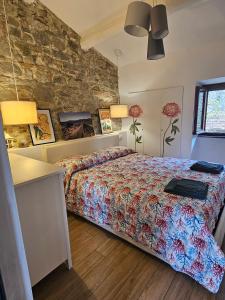 una camera con letto e parete in pietra di I Colori del Lago a Passignano sul Trasimeno