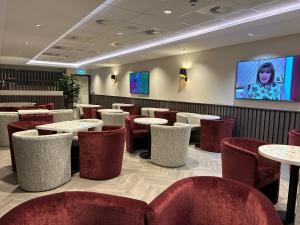 a restaurant with tables and chairs and a flat screen tv at Tynecastle Park Hotel in Edinburgh