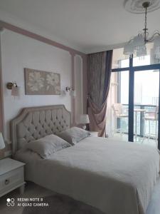 a bedroom with a large bed and a balcony at Dream apartment in Batumi