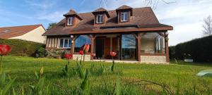 una pequeña casa en un campo de césped verde en Jolie maison à 800m de la plage, en Hermanville-sur-Mer