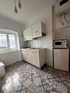 uma cozinha com electrodomésticos brancos e piso em azulejo em Olivetta House Holiday em Moneglia