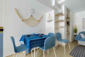 a dining room with a blue table and chairs at Voiles de Golfe in Vallauris