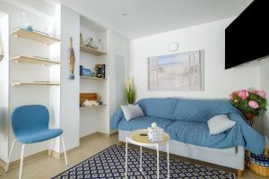 a living room with a blue couch and a table at Voiles de Golfe in Vallauris