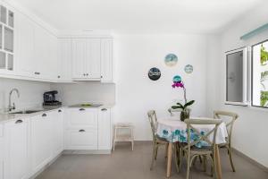 a kitchen with white cabinets and a table and chairs at El Pasero in El Golfo +17 photos