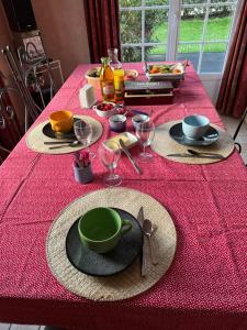 una mesa con un mantel rojo con una placa verde en les chambres de la grange, en Saint-Germain-de-la-Grange