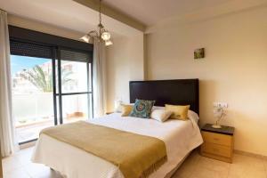 a bedroom with a large bed with a large window at Vera Almería - Mar y Piscinas in Vera +30 photos