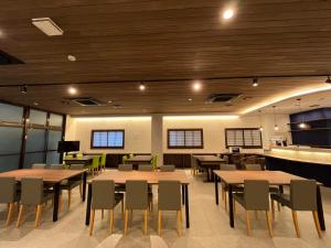 a restaurant with wooden ceilings and tables and chairs at Sakuraya in Miyajima