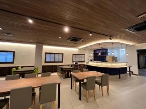 a restaurant with wooden ceilings and tables and chairs at Sakuraya in Miyajima