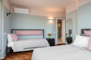 2 Betten in einem Zimmer mit rosa und weiß in der Unterkunft Affittacamere Filomare, caffe, breakfast in Marcelli