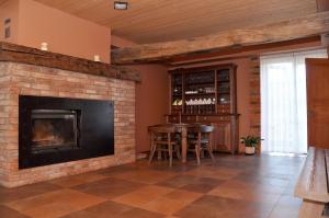 a living room with a fireplace and a table and chairs at Viesu nams Bezdubeņi in Sukturi