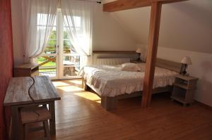 ein Schlafzimmer mit einem Bett und einem großen Fenster in der Unterkunft Viesu nams Bezdubeņi in Sukturi