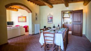 a dining room with a table and a living room at LA TORRE DEI FAGIANI 8&2 Emma Villas in Castiglione del Lago
