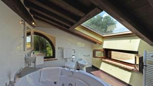 a bathroom with a large tub and two toilets at LA TORRE DEI FAGIANI 8&2 Emma Villas in Castiglione del Lago +25 photos