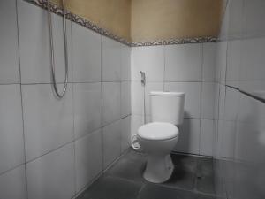a white bathroom with a toilet and a shower at Kadek Homestay in Besakih