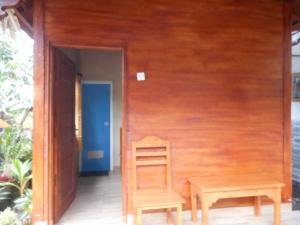einen Holzstuhl und einen Holztisch auf einer Veranda in der Unterkunft Kadek Homestay in Besakih
