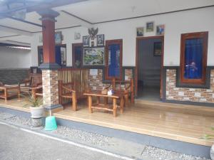 a house with wooden tables and chairs on a deck at Kadek Homestay in Besakih