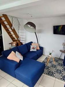 um sofá azul numa sala de estar com uma escada em Jolie Maisonnette avec terrasse en bois em Saint-Médard-en-Jalles