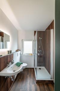 uma casa de banho com um lavatório e um chuveiro em Haus Dina em Bodenwerder