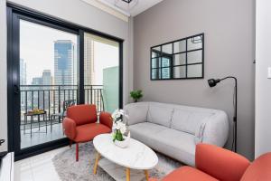 sala de estar con sofá y sillas y balcón en CitiHome - Newly Furnished Apartment in Business Bay, en Dubái