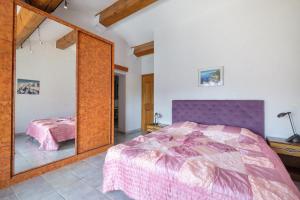 een slaapkamer met een paars bed en een spiegel bij Numéro 2 in Valbonne