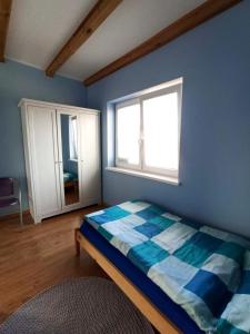 Schlafzimmer mit einem Bett und einem Fenster in der Unterkunft Kostek in Rowy