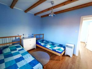 a bedroom with two beds and a blue wall at Kostek in Rowy