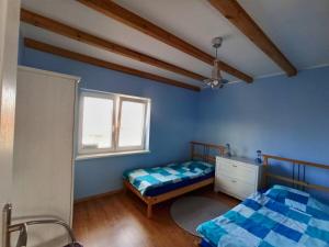 a bedroom with two beds and a window at Kostek in Rowy