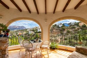 a room with two arched windows and a table and chairs at Apartament in Monte Pedreguer in Pedreguer
