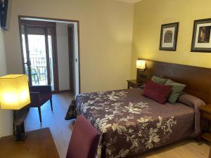 a bedroom with a bed and a desk and a lamp at Hotel Cinca in Escalona