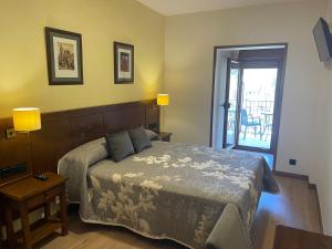 1 dormitorio con 1 cama y puerta que da a un patio en Hotel Cinca en Escalona