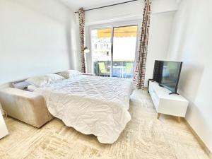 a white bedroom with a bed and a tv at BB P Terrasse des Bougainvillees - Promenade des A in Nice