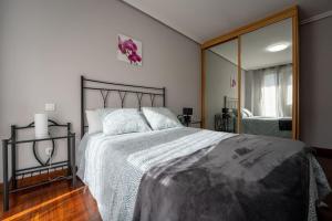 a bedroom with a large bed and a large mirror at Elegante Espacio Residencial in Santa Cruz de Bezana