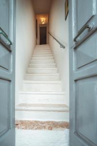 a flight of stairs with a blue door at Fior di Giglio Historic House - Housea Travel in Polignano a Mare
